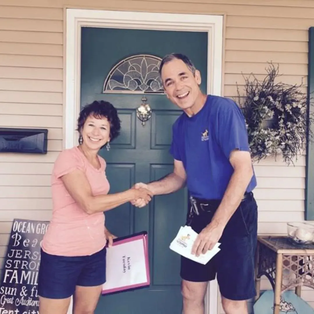 Founder Tom Watson shaking hands on a front porch